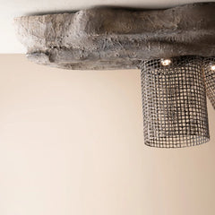 A rustic industrial ceiling tight with a textured gray faux-stone top and a black meta mesh