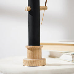 Black ceramic incense holder with wooden holder on a white surface