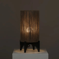 Table lamp with textured brown shade with ambient lighting on a dark background