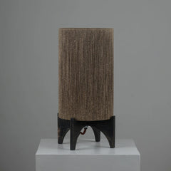 Ambra Table Lamp - Textured jute brown lampshade on a black stand against a gray background