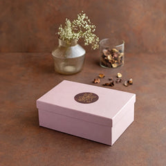 A rectangular light pink gift box with a matching lid, featuring a Yin Nut bowl plus 4 matching rectangle coasters in black marble and brass.
