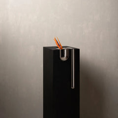 A modern black rectangular Bookcase Vase with a polished silver metallic vertical handle and a small cup-like opening at the top.