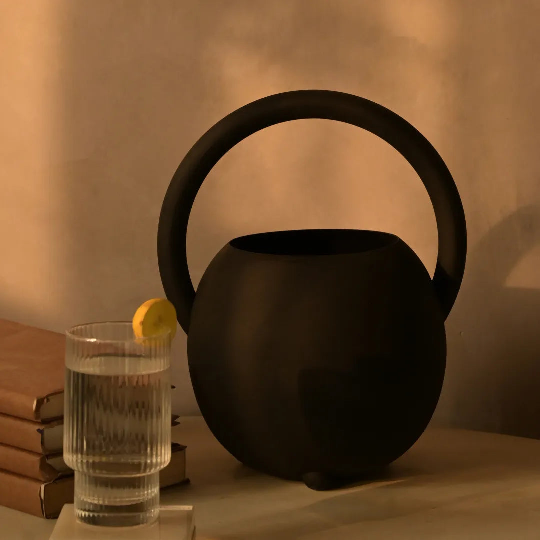 Modern decor piece- Black Halo Vase on a wooden surface against a beige background