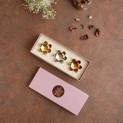Lotus Blossoms _ Gift Box, top view of three brass lotus tealight holders packed in open pink box with lid