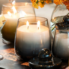 Cosmic Hues - Lid Jar Candle | Blue | Balmy Bergamot, lit two-wick jar among candles and flowers, lifestyle close-up