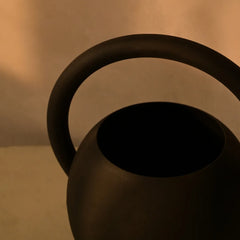 Black Halo Vase like a teapot design with handle on a beige background