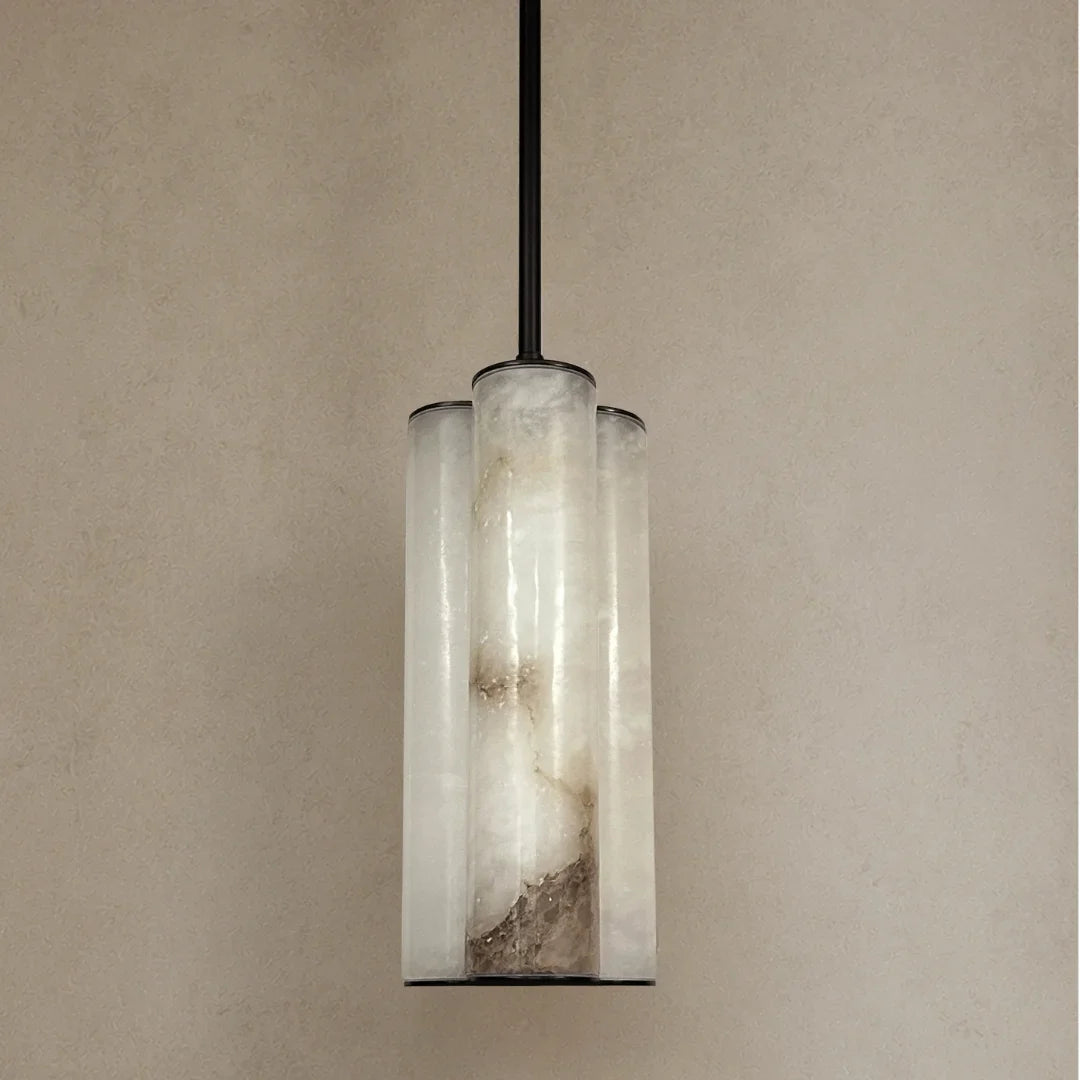 Single Pendant light fixture with cylindrical glass shades on a beige wall.