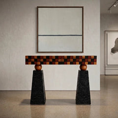 Tessaro Console Table with checkered mosaic wood front and textured black pedestals in a gallery room