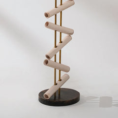 Spiral sculpture made of beige pipes and a dark base on a white background