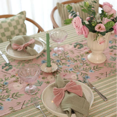 Valley Rose Linen Table Runner with pink bow napkin and green taper candle, close view