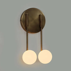 Loop wall sconce with two arms and round glass globe lights on a gray background