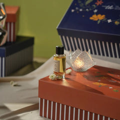 A room perfume bottle is placed on red gift box.