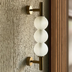 Close-up of glass orb wall sconce detail and metal mount finish