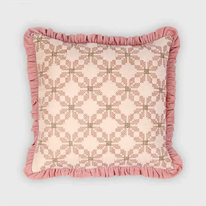 A square decorative throw pillow with a pink and beige geometric pattern and a ruffled dusty pink border, shown against a light gray background.