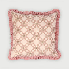 A square decorative throw pillow with a pink and beige geometric pattern and a ruffled dusty pink border, shown against a light gray background.