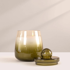 Cosmic Hues - Lid Jar Candle | Olive Green | Sage Cleanse, lit olive glass jar with bell lid resting in front