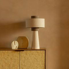 Beige Iris Table Lamp and decorative items on a wooden surface against a beige wall