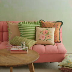 Annabella Amber Linen Cushion Cover on pink sofa behind round wooden coffee table