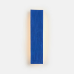 A vertical blue wall sconce fixture with a white background.