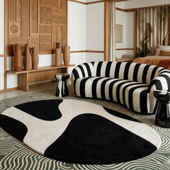 Modern living room with a black and white striped sofa and cow print rug.