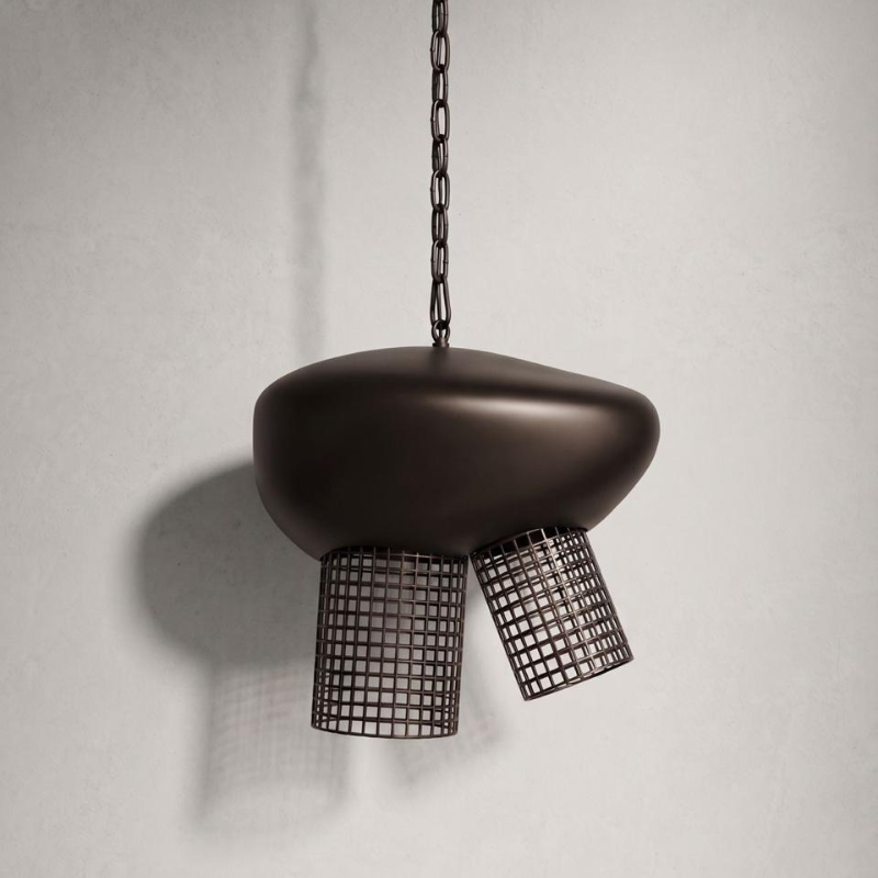 A modern pendant light fixture with a matte dark brown organic-shaped shade and two hanging wire mesh shades, suspended from a dark metal chain against a light gray wall.
