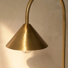 Hush Table Lamp with a gold cone-shaped shade against a neutral background