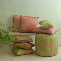 Viola Forest Green Cotton Cushion Cover stacked with coordinating cushions beside a pouf