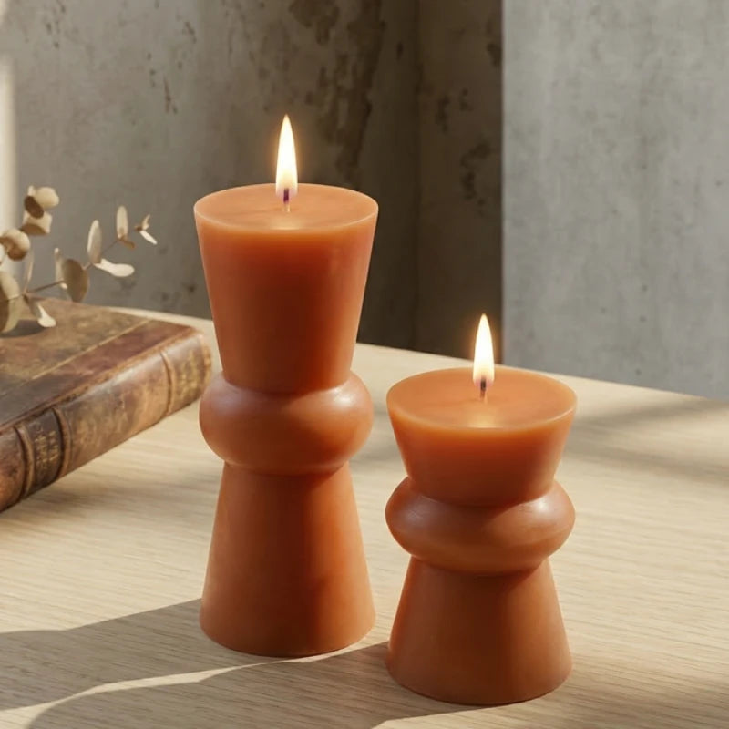 Modern Pillar Candle Non Scented, two lit chilli red sculptural pillars on a wooden surface