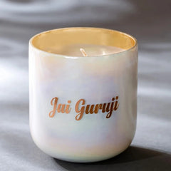 Jai Guruji | U-Glass Candle | Flower Blossom Scented, white pearl lustre glass with gold rim on dark draped fabric
