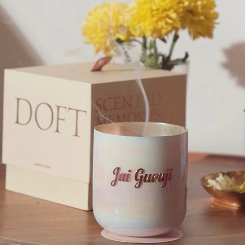 Jai Guruji | U-Glass Candle | Flower Blossom Scented, pearl lustre glass with rose gold script beside Doft box