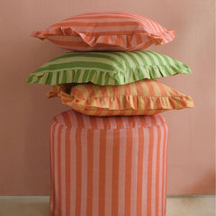 Linea Ruffle Amber Cotton Cushion Cover stacked on striped pouf with ruffled cushions