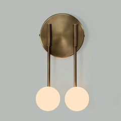 Loop wall lights with two round glass shades casting warm light