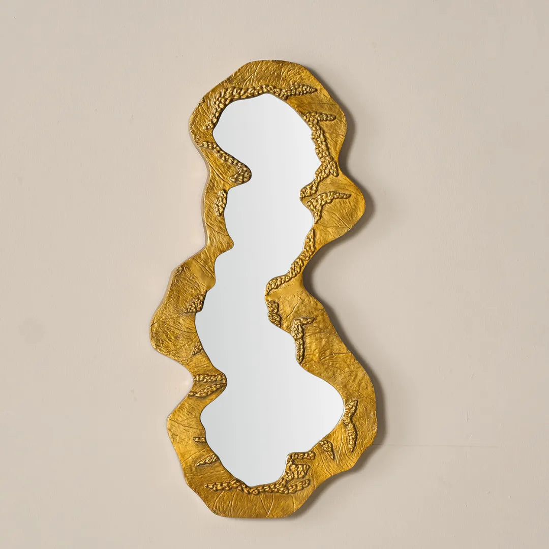 Kinara mirror with aluminium gold textured frame on a beige background