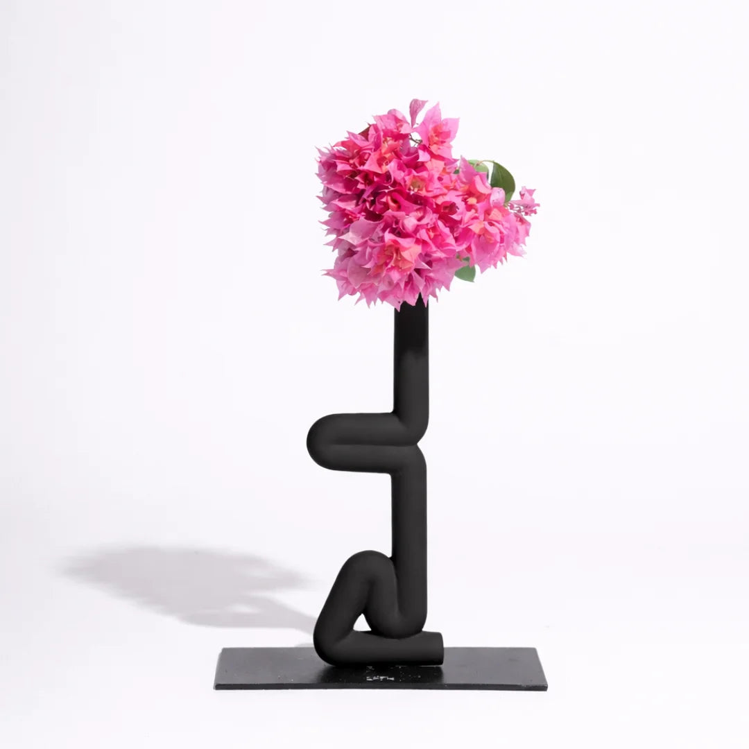 Modern black Sirsasana Vase with pink flowers on a white background