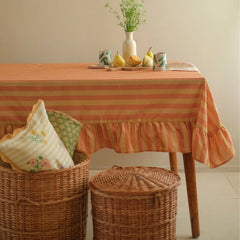 Linea Ruffle Amber Cotton Table Cover on dining table with wicker baskets and cushions, full view