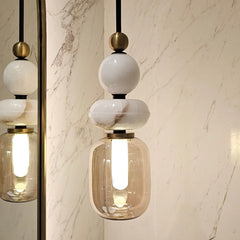 Modern pendant light hanging with glass shades and brass accents 