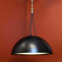 Brio Beach Villa Black pendant light against a red wall