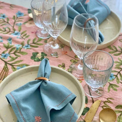 Valley Rose Linen Table Runner with blue napkins and crystal glassware, top view
