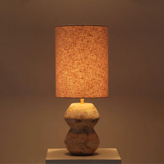 Cascata Table Lamp with a textured fabric shade and marble base, glowing light