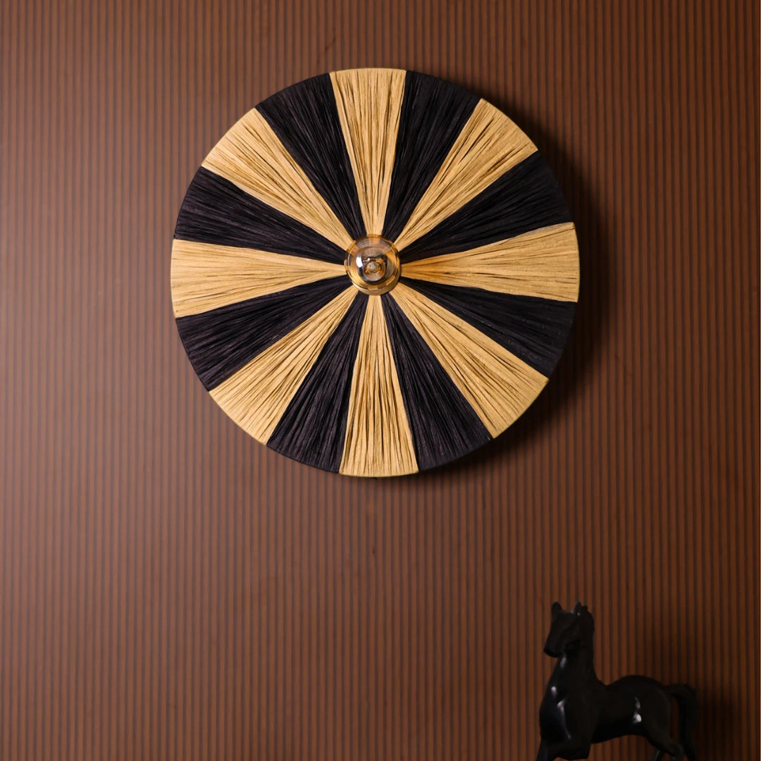 Decorative Fiore wall lamp with black and natural raffia in circular design on a brown wall.