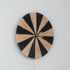 Round Decorative Fiore wall light with black and natural raffia striped design.