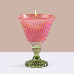 Sundae Votive Candle - Petal · Berry Blonde, lit pink sundae glass candle on plain backdrop