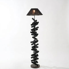 Spiral wooden floor lamp with a black shade on a white background