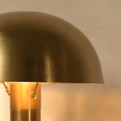Close-up of a gold Lumo Table Lamp with a warm glow on a neutral background