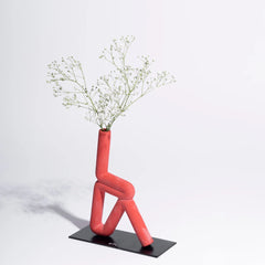 Pink abstract Trikonasana Vase with a plant on a white background