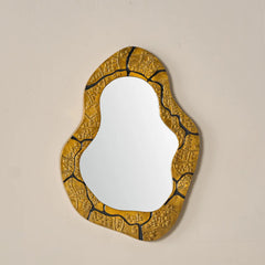 Small size Kinara mirror with aluminium gold and black textured frame on a beige wall