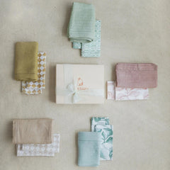Powder Blue Linen Table Runner with assorted folded linens and gift box, flat lay