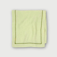 Mirage Pistachio Linen Table Runner folded, showing green embroidered triangle border