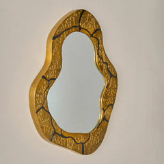 Kinara wall mirror, medium size with aluminium gold textured frame on a beige background