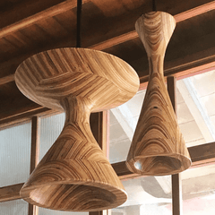 Two Hourglass shaped Pendant Lamps hanging from ceiling.  Sculpted Natural Ply Design features lathe-turned plywood in an elegant hourglass silhouette